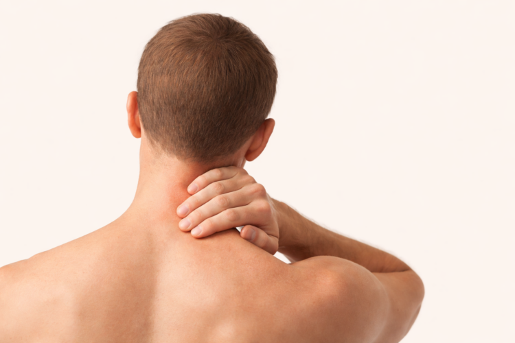 Person holding the back of their neck, illustrating neck pain and tension.